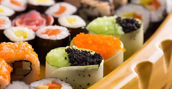 A variety of sushi options at the appetizer counter: salmon roe sushi, fresh salmon sushi rolls, seaweed-wrapped sushi….